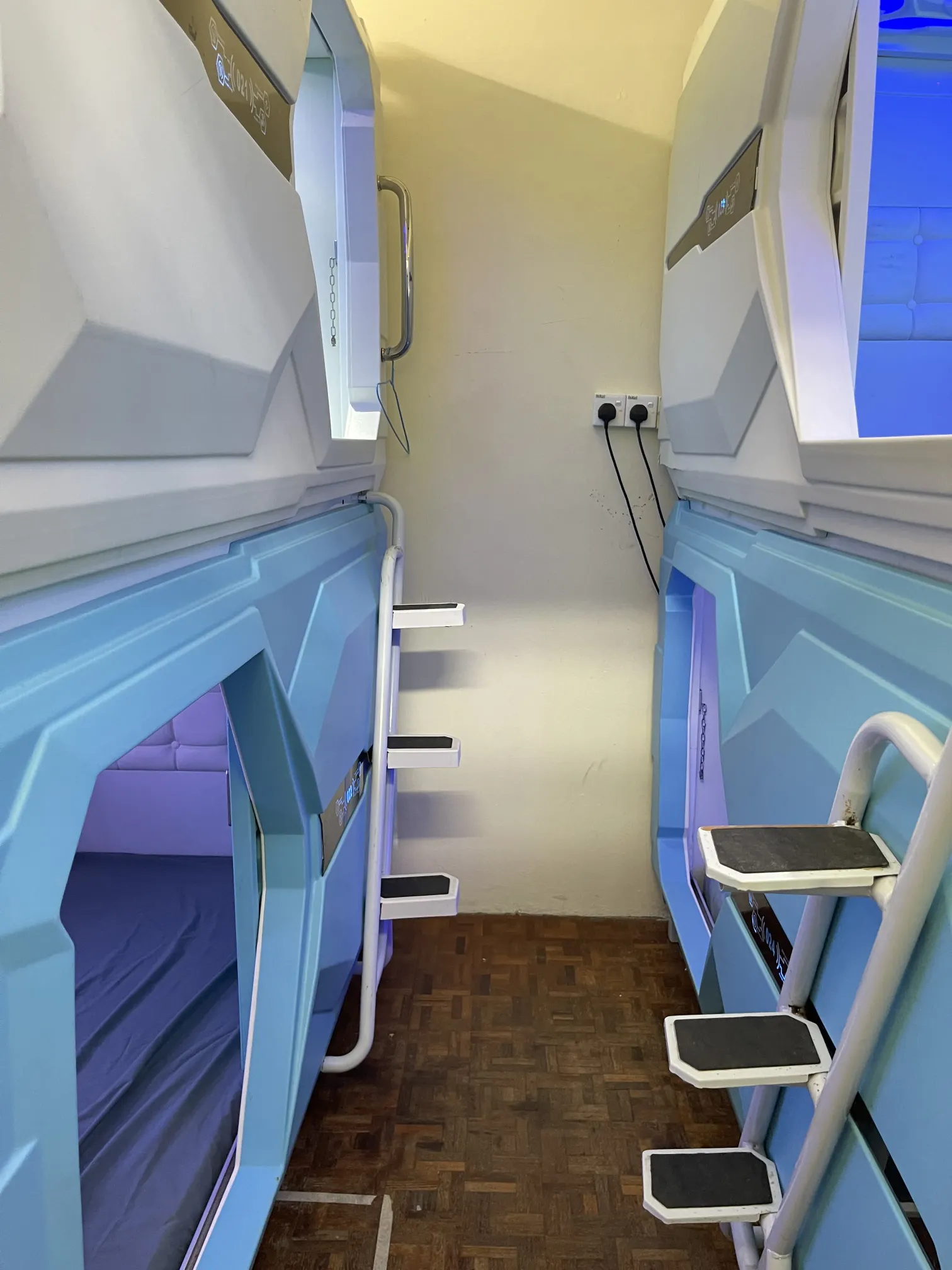Japanese-style capsule pod interior with privacy features at budget hostel JB